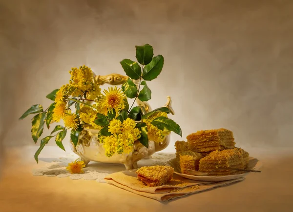 Bodegón con flores amarillas y un pastel — Foto de Stock