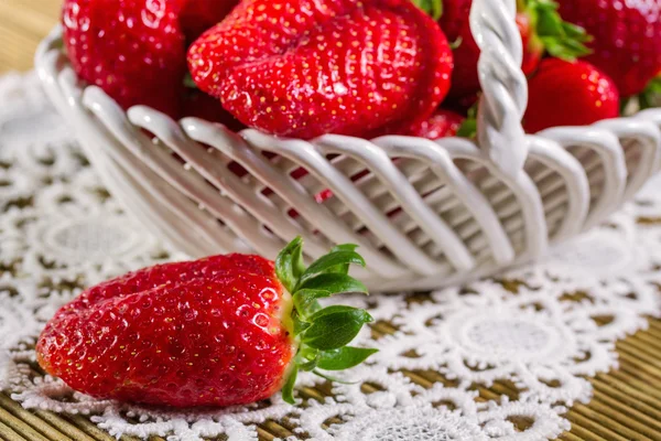 Fresas maduras en canasta de cerámica sobre fondo de madera — Foto de Stock