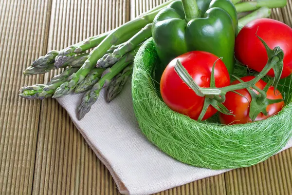 Frischer Spargel mit Gemüse auf Holzuntergrund — Stockfoto