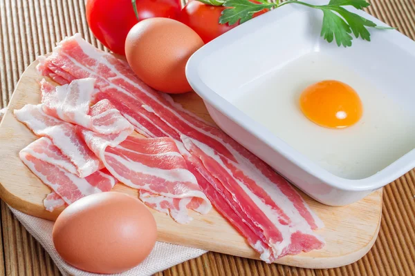 Um delicioso bacon e ovos em um fundo de madeira — Fotografia de Stock