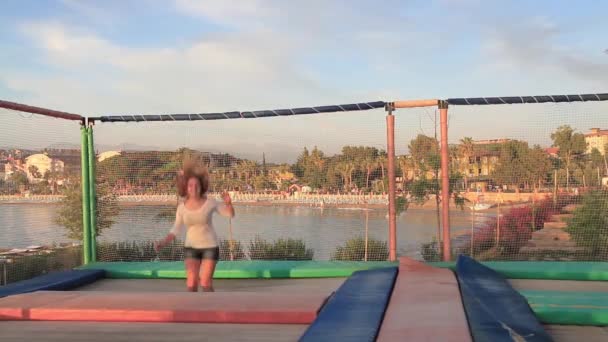 Девушка прыгает на батуте — стоковое видео