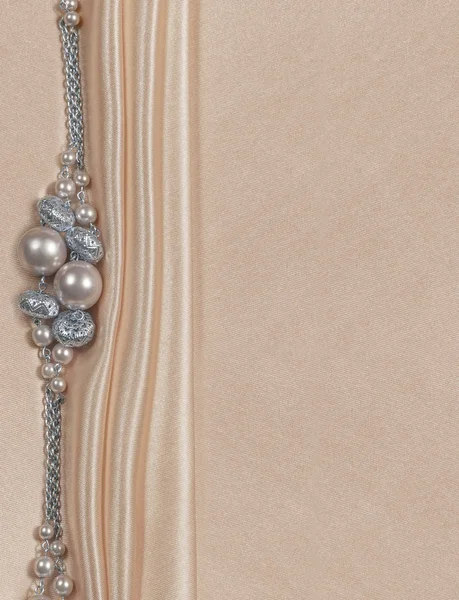 Delicate satin background with beads — Stock Photo, Image