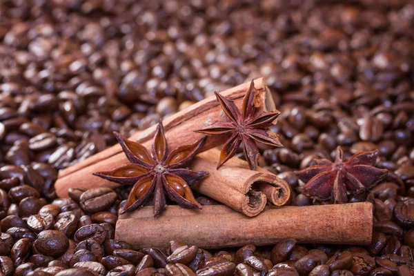 Palitos de canela y anís estrellado sobre un fondo de granos de café —  Fotos de Stock