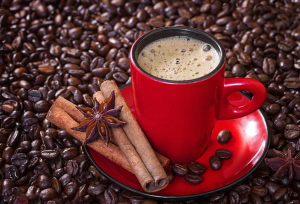 Кофе в красной чашке с корицей и анисовыми звездами . — стоковое фото