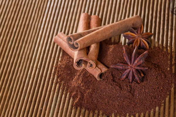 Café molido con canela y anís estrellado sobre un fondo de madera — Foto de Stock