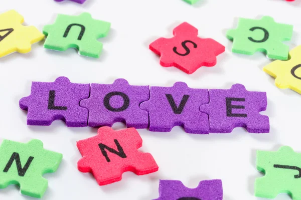 Woord liefde gevormd met kleurrijke schuim puzzel op witte achtergrond — Stockfoto