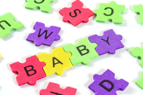 Слово BABY формируется с красочной головоломки пены на белом фоне — стоковое фото