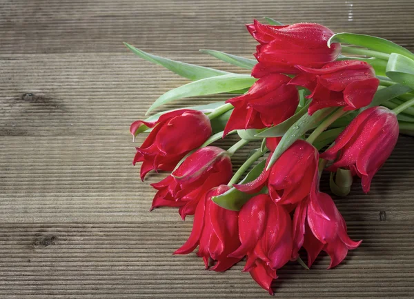 木制背景上的郁金香花束 — 图库照片