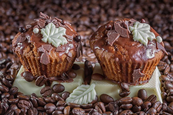 Chocolate muffins on the background of coffee beans. — Stock Photo, Image