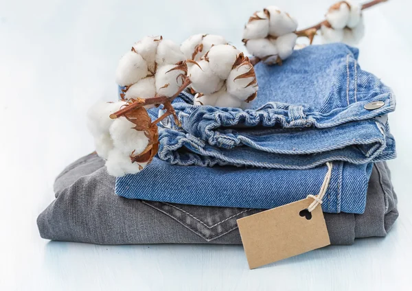 Stapel van kleding met een takje van katoen — Stockfoto
