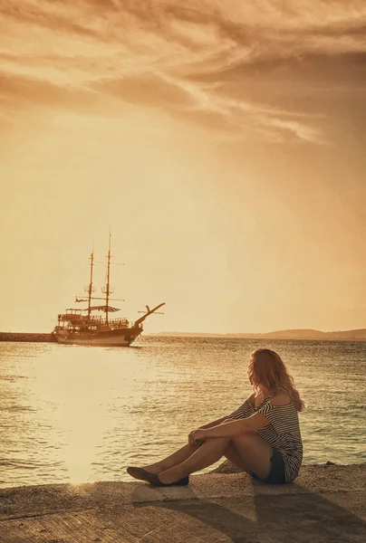 Girl on quay at the sea looking at the ship  with retro filter e — Stock Photo, Image