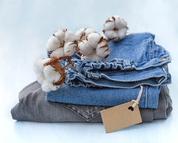 Stack of clothes with a sprig of cotton — Stock Photo, Image