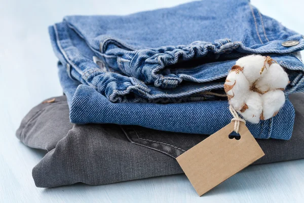 Stapel van kleding met een takje van katoen — Stockfoto