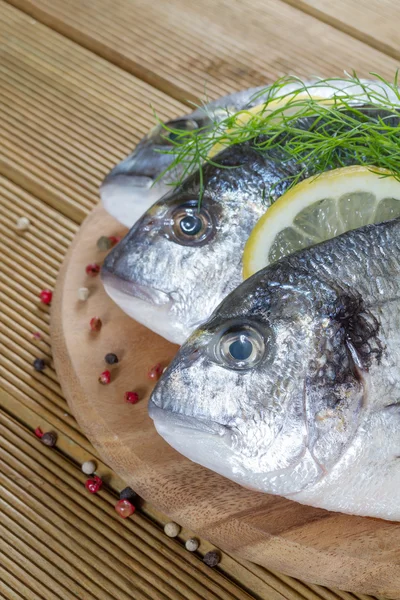 Dorado fresco su uno sfondo di legno — Foto Stock