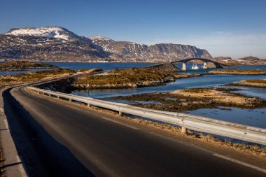 Norwegian road between islands with bridge uder witch goes boat   