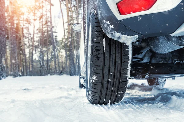 Närbild detalj syn på bilhjul med osäkra sommar slitbanedäck under körning genom hala snö väg på vintern. Risk för kollision med trafikolyckor. Koncept för säsongsbunden däckbrytare — Stockfoto