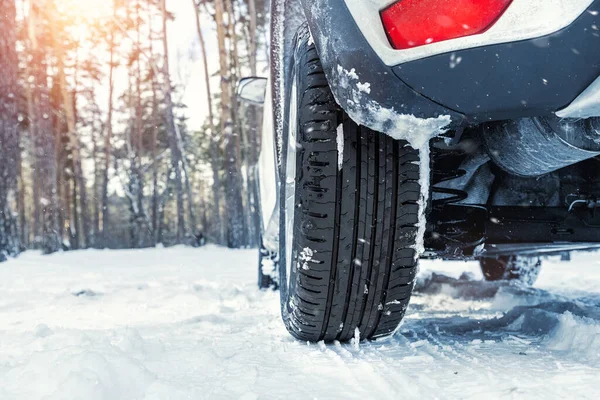 Vista detallada de cerca de la rueda del coche con neumático de banda de rodadura de verano inseguro durante la conducción a través de carretera de nieve resbaladiza en la temporada de invierno. Riesgo de colisión de accidentes de tráfico. Concepto de interruptor de neumático estacional —  Fotos de Stock