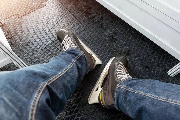 Vista de detalle de cerca de las piernas de las personas masculinas que usan jeans y botas de patinaje de alquiler negras paradas en una alfombra suave de goma antideslizante en la pista de patinaje de vestuario. Recreación saludable actividad de ocio — Foto de Stock