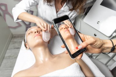 Sosyal medya ağındaki çevrimiçi atölye ana sınıfı için kozmetik doktoru yüz bakımı eğitiminin canlı video akışını elde tutan akıllı telefon. Uzak mesafe öğrenme kavramı