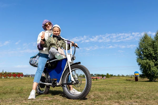 Junge Erwachsene schöne Mutter und Tochter genießen Spaß beim Fahren Elektro-Scooter Fahrrad oder ländlichen Feldweg an einem sonnigen Tag. Mutter mit Kind Roadtrip Natur Abenteuer Reise dobropark — Stockfoto