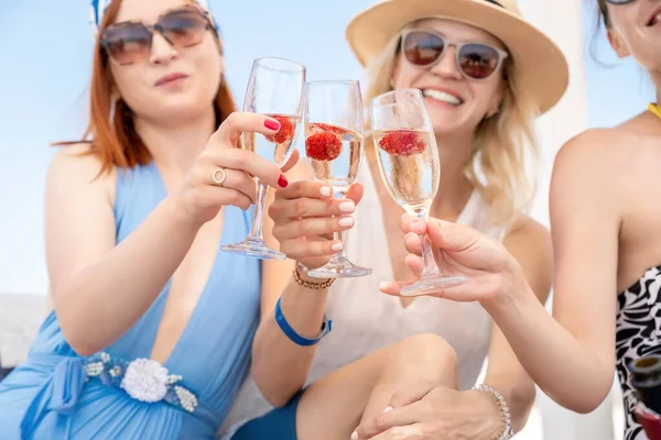 Portrait group of three young adult beautiful caucasian girlfriends enjoy drinking champagne cocktail celeberate bachelorette party event pool seaside beach on summer day. Friends cheers clink wine