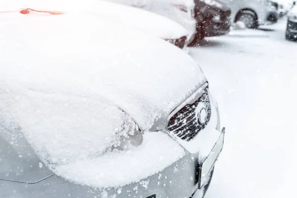 Autók parkoltak sorban a szabadtéri parkolóban télen. Hóval borított járművek nagy hóesés idején. Hóvihar vagy hóvihar hideg évszak időjárás előrejelzés. Ice storm automobile park telek tárolás reggel — Stock Fotó
