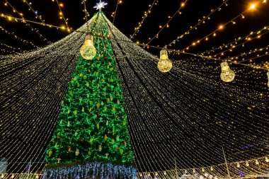 Dekorasyonlarla süslenmiş güzel Noel Ağacı arka plandaki Sofya Katedrali 'ne karşı hafif çelenklerle aydınlatılmış. Mutlu 2022 Yeni Yıl ve xmas Kutlamaları