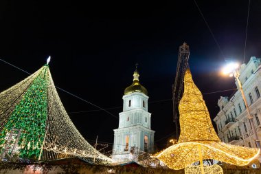 Dekorasyonlarla süslenmiş güzel Noel Ağacı arka plandaki Sofya Katedrali 'ne karşı hafif çelenklerle aydınlatılmış. Mutlu 2022 Yeni Yıl ve xmas Kutlamaları