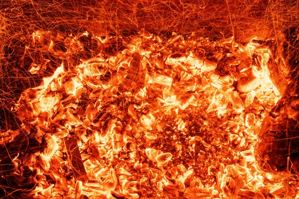 In alto sopra sopra dettaglio sopraelevato vista od astratto caldo rosso bruciore fondo carbone in barbecue griglia braciere o focolare a notte scura. Bella inferno calore scintille ardente fiammeggiante al focolare stufa — Foto Stock