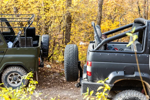 夏の日没の朝の太陽の下で未舗装の砂利未舗装道路上の2つの4 × 4ソビエトのSUVカバートップ車両のペア.オフロードカー山サファリアドベンチャー自然旅行の旅のコンセプト。ATV狩猟レンタル — ストック写真