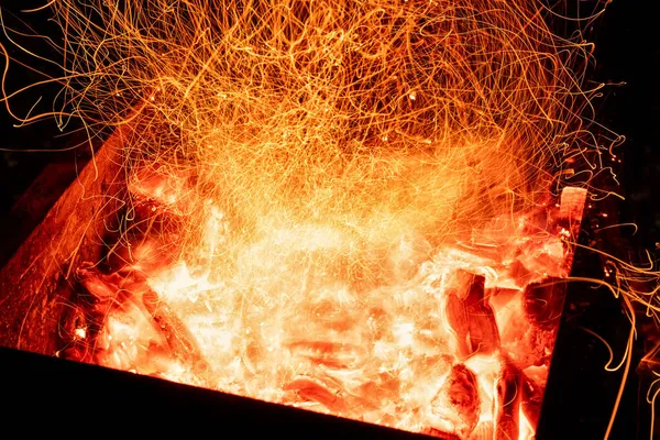 Κορυφή πάνω από τα γενικά λεπτομέρεια άποψη od αφηρημένη ζεστό κόκκινο καύση ξύλινο φόντο άνθρακα σε bbq ψησταριά brazier ή firepit σε σκοτεινή νύχτα. Όμορφη κόλαση θερμότητας σπινθήρες λαμπερό φλεγόμενο στην εστία σόμπα — Φωτογραφία Αρχείου