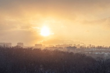 Şehrin panoramik arka planına karşı kar fırtınası tipide hava aracıyla sabah güneşinin doğuşunu izleyeceğiz. Kar fırtınası ve güneşli hava