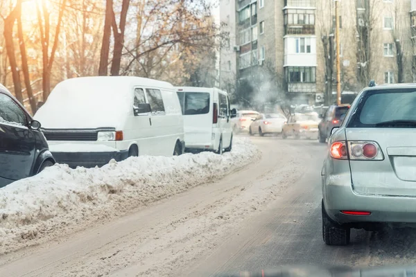 Carros que se movem na rua da cidade no inverno de estrada nevado escorregadio. Veículos cobertos com neve deriva nevasca estação fria de inverno. Temporada fria mau tempo condições extremas de condução. entrada de lamas — Fotografia de Stock