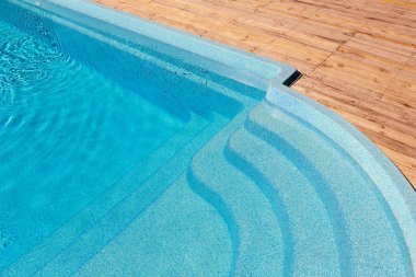 Yeni modern fiberglas plastik havuz girişi tersanede ya da otel spa alanında temiz, ferahlatıcı mavi su ile. Tahta döşeme tahtası ya da karaçam tahtası.