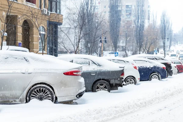 City Street uppfart parkeringsplats med många bilar täckta av snö stucken efter tung snöstorm snöfall på vinterdagen av smutsiga snöiga högen. Snödrivor och frusna fordon. Extrema väderförhållanden — Stockfoto