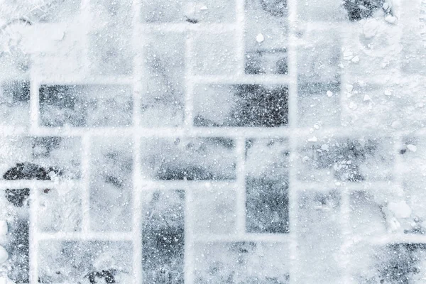 Top aboe fölött kilátás kő lapos járda borított hó hideg téli napon. Lábnyomok csúszós felületen. Időjárás előrejelzés. Absztrakt téli textúra háttér. A szöveg másolási helye — Stock Fotó