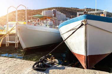 Parlak güneşli bir günde balıkçı köyü marinasına demirlemiş pek çok küçük, eski, ahşap renkli, parlak balıkçı teknesi. Geleneksel geçmişe sahip deniz limanı