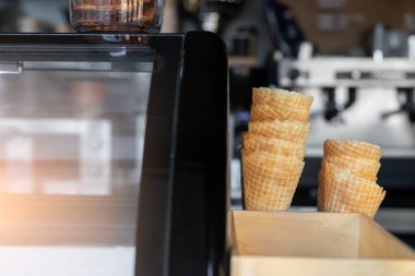 Bir sürü boş waffle konisi ve dondurmalar için kağıt bardaklar sokak yemeklerinin vitrinine istiflenmiş. Tatlı tatlılar ve sıcak çay kafeteryası.
