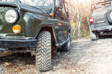 Eski model 4x4 Sovyet SUV aracıyla yazın gün batımında asfaltsız yollarda. Off road car Mountain safari macera doğa yolculuğu konsepti. ATV Kiralama .