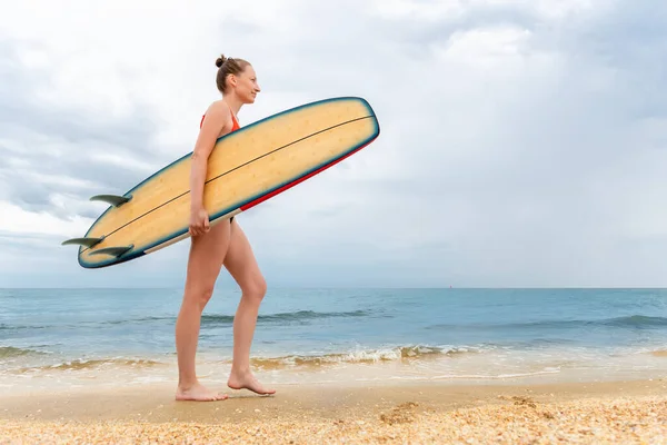 Side profile view jong volwassen slanke sportieve vrouwelijke surfer meisje genieten van plezier zwemmen surfplank oceaan kust golf helder water zonnige dag. Sport gezonde zorgeloze hobby lifestyle vakantie concept — Stockfoto