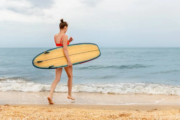 Πλάγια προβολή προφίλ νεαρός ενήλικας λεπτό σπορ θηλυκό surfer κορίτσι απολαμβάνουν τη διασκέδαση κολύμπι ιστιοσανίδα κύμα ακτή του ωκεανού καθαρό νερό ηλιόλουστη μέρα. Αθλητισμός υγιή ξέγνοιαστο χόμπι έννοια διακοπών τρόπο ζωής — Φωτογραφία Αρχείου
