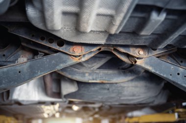 Alttaki araba parçasının paslı süspansiyon kolu parçası ile yakın plan detaylı görünümü için yenileyici servis ya da bakım gerekir. Araç şasisi garanti tamiri. Otomotiv mekaniği endüstriyel arka plan