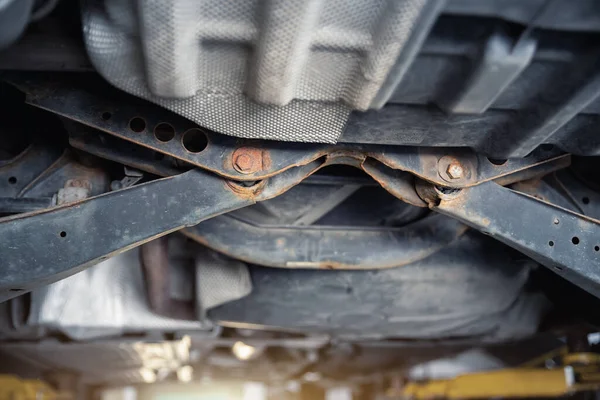 Close-up detail view of bottom car part with rusty broken suspension arm part need replacemant service or maintenance. Vehicle chassis stain warranty repair. Automotive mechanic industrial backround — Stockfoto