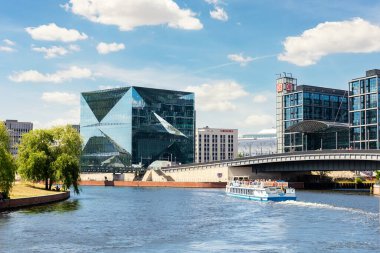 Güneşli bir günde Spree Nehri 'nde yelken açan turizm gemisinden Berlin DB tren istasyonu yakınlarındaki modern iş merkezinin manzaralı manzarası. Almanya sefalet içinde seyahat ediyor. 16 Haziran - Berlin, Almanya.