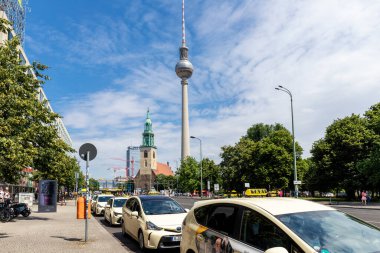 16 Haziran, Berlin, Almanya. Birçok taksi durağı Berlin şehir merkezinde ünlü Berlin TV kulesi St Mary Kilisesi Alexandrplatz mavi gökyüzü arka planının karşısında turist bekliyor. Alman seyahat konsepti.