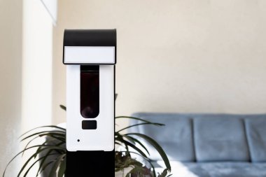 Close-up detail of smart automatic touchless hand sensor sanitizer disinfectant spray dispenser machine device office entrance, hospital or shopping mall. Pandemic healthcare and hygiene disinfection.