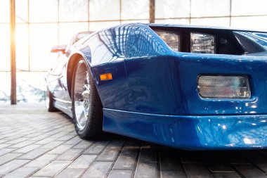 Kapalı çekimli ön tekerlek pov blue vintage eski Amerikan arabaları garajda park edilmiş, sergi festivali. Yakın plan detay görüntüsü güzel eski zaman aracı kaputu, far, çamurluk ve parlak tampon..