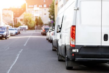 Avrupa şehir merkezine park edilmiş küçük bir kargo minibüsü. Orta kamyonlu minivan kurye aracı şehir merkezindeki bir ofis binasında paket teslim ediyor. Ticari nakliye lojistiği.