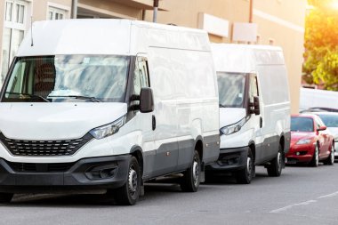 Avrupa şehir merkezine park edilmiş küçük bir kargo minibüsü. Orta kamyonlu minivan kurye aracı şehir merkezindeki bir ofis binasında paket teslim ediyor. Ticari nakliye lojistiği.