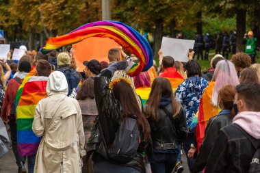 Ukrayna 'nın Kyiv kentindeki Onur Yürüyüşü' ne katılanlar ellerinde gökkuşağı bayrakları ve posterlerle kentin sokaklarında yürüyorlar. Gençlerden oluşan bir kalabalık. Konsept LGBTQ.